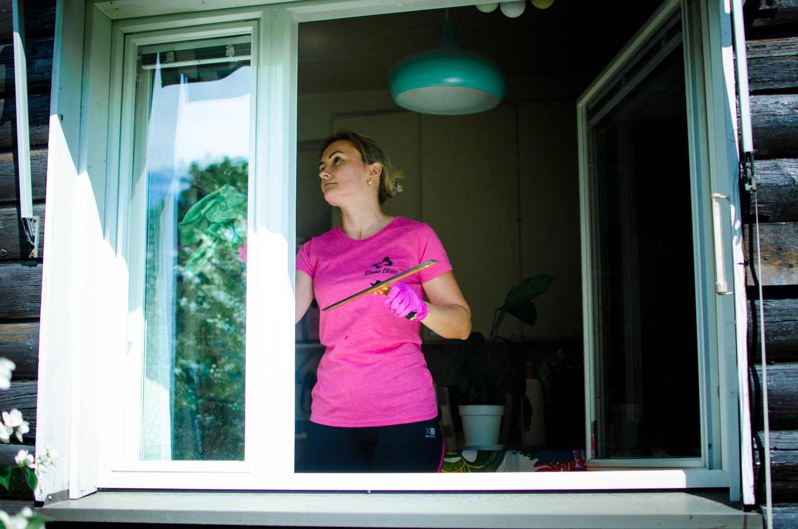 Siivous Eliitti suorittamassa ikkunapesua asiakkaan omakotitalon keittiön ikkunaan taaten kirkkaan ja puhtaan lopputuloksen.